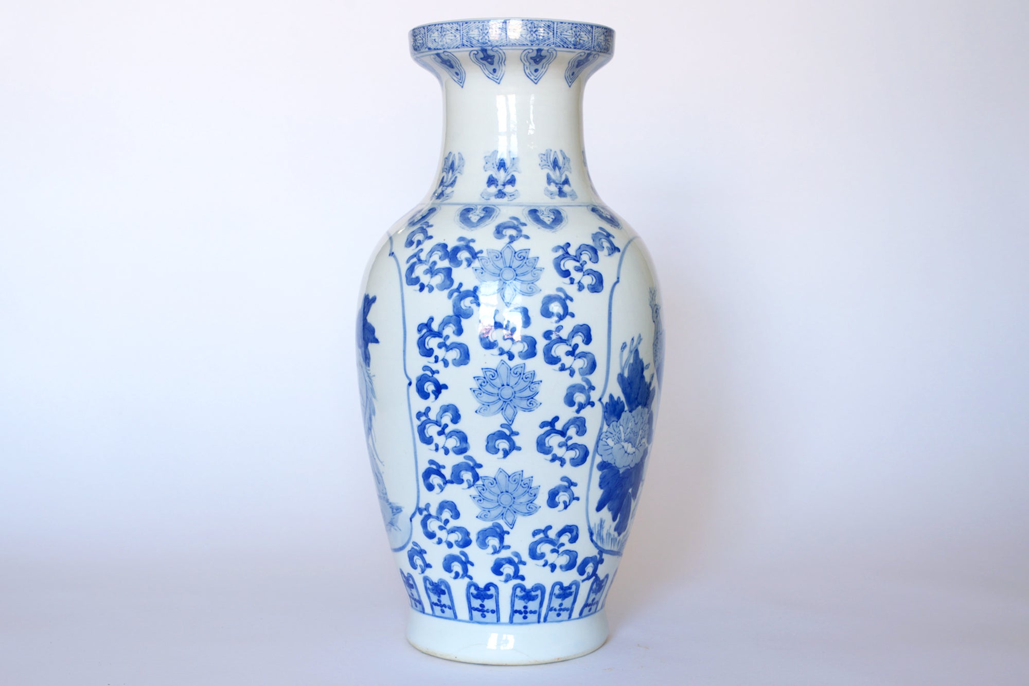 The Euro Trash Vintage Blue & White Porcelain Peacock Vase features a tall, wide-body design with blue floral and decorative patterns, a narrow neck, and classic Asian-inspired style—perfect for elegant decor.