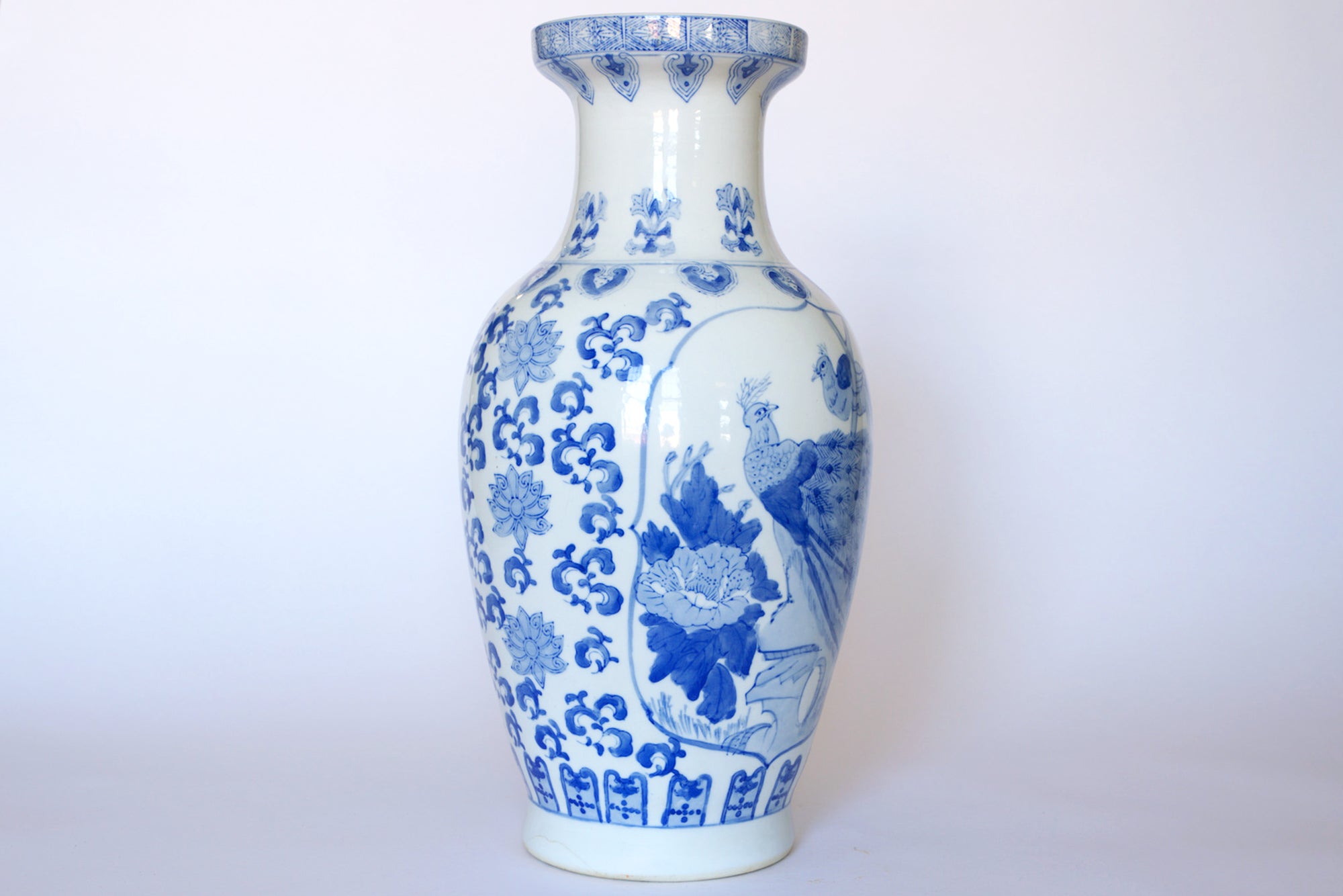 The Euro Trash Vintage Blue & White Porcelain Peacock Vase features intricate floral patterns and a detailed peacock design—an elegant Asian-inspired decor piece perfect for any space.