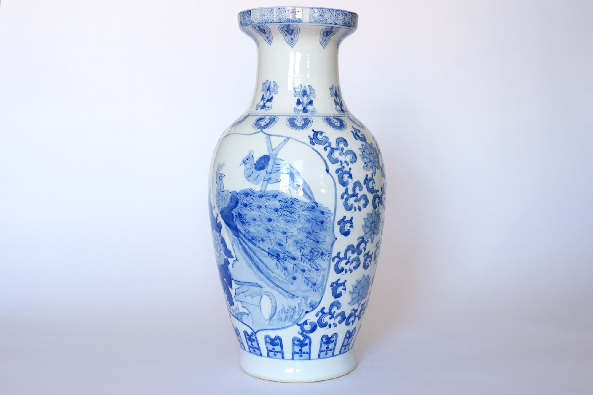 The Euro Trash Vintage Blue & White Porcelain Peacock Vase features intricate peacock and floral designs, embodying elegant Asian-inspired decor and vintage charm—perfect as a standout piece against any white background.