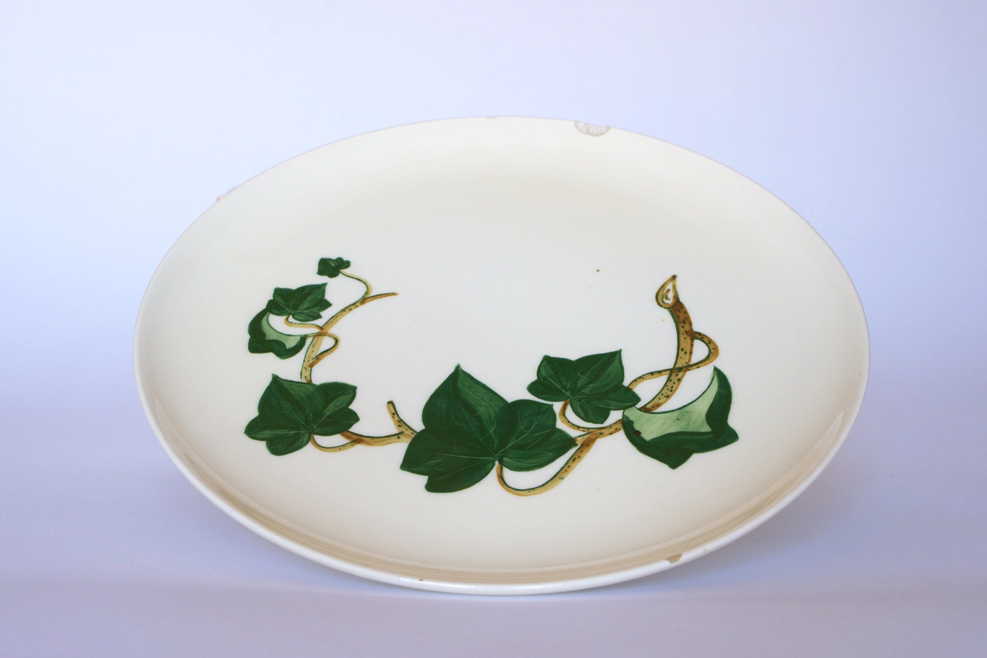The Vintage Ivory Ceramic Bowl with Ivy Leaf by Euro Trash features a decorative green ivy and brown vine design on white ceramic—ideal as a vintage centerpiece or serving bowl for your table.