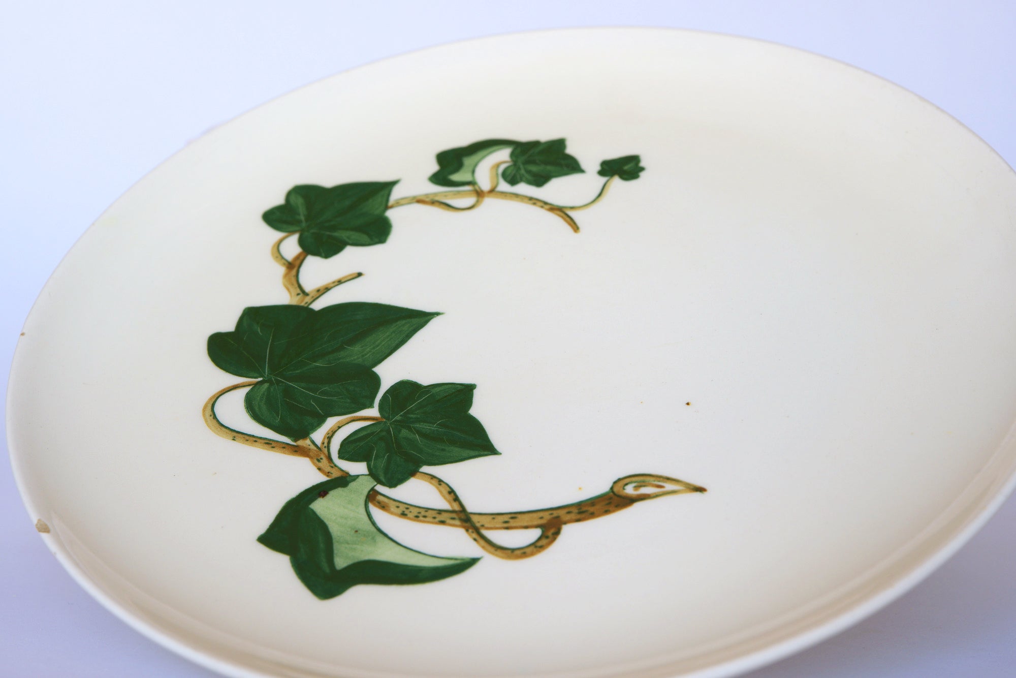 The Euro Trash Vintage Ivory Ceramic Bowl with Ivy Leaf features hand-painted ivy leaves and vines with a yellow and brown snake—ideal as a decorative centerpiece.