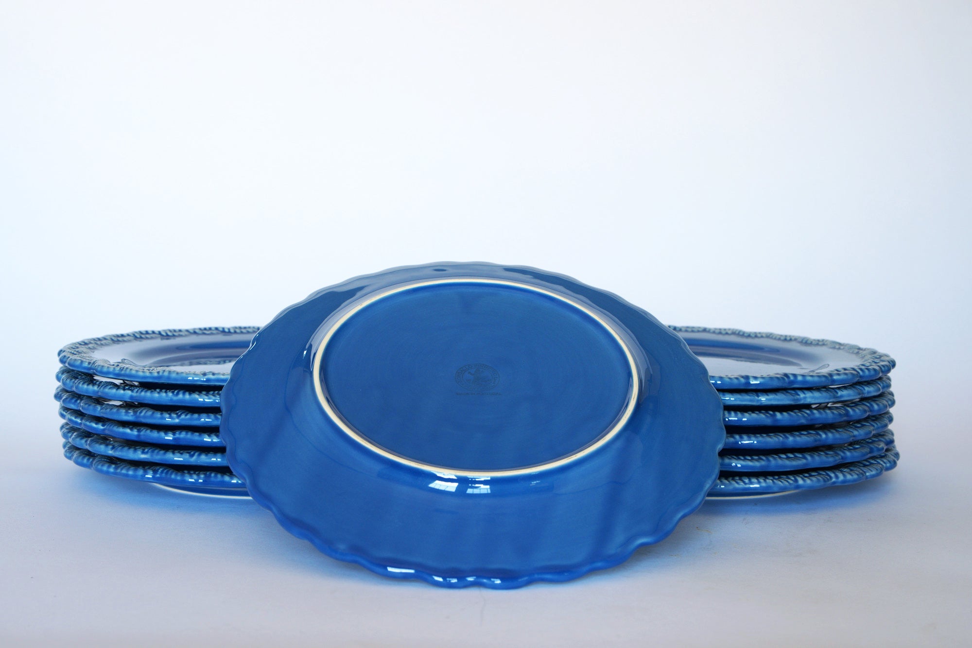 A set of nine Euro Trash Vintage Blue Rim Dinner Plates with Beaded Edge is displayed on a plain white background, with one plate propped up to show its underside.