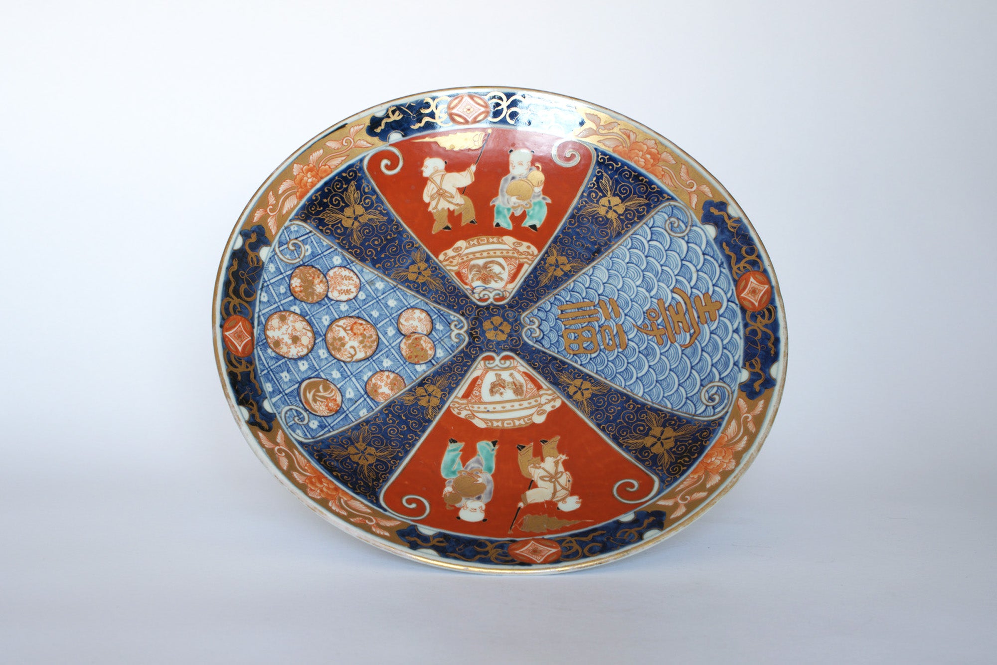 The Euro Trash Vintage Imari Style Porcelain Decorative Plate features red, blue, and gold Asian-inspired patterns—figures, circles, and waves—on white. Ideal as a striking decorative wall plate.