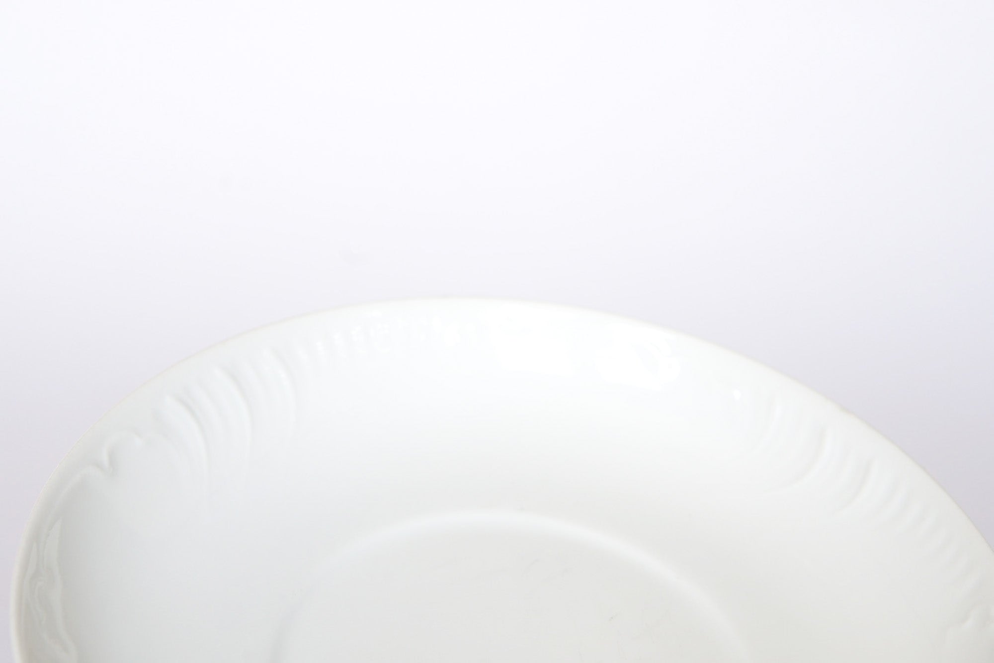 A close-up of the Euro Trash Vintage White Embossed Rim Ceramic Bowl highlights its delicate embossed details, set against a white background.