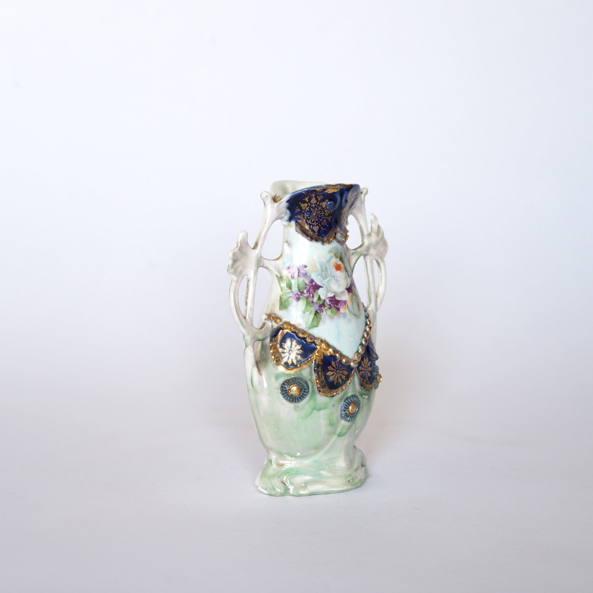 The Euro Trash Vintage Blue & Gold Porcelain Trinket Dish features elegant floral patterns and ornate gold accents, beautifully displayed against a plain white background.