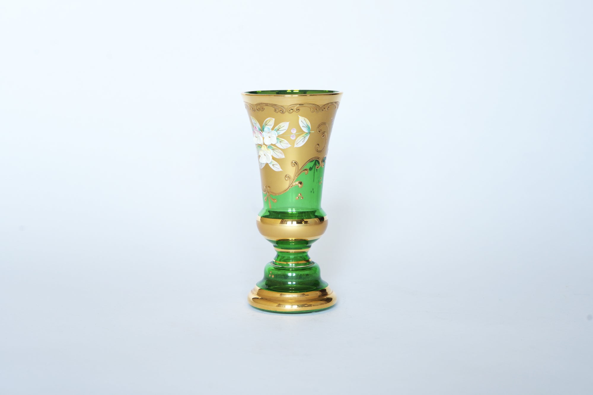 The Euro Trash Vintage Green & Gold Hand-Painted Floral Glass Vase features elegant emerald glass with white flowers and gold accents, capturing vintage charm against a plain white background.