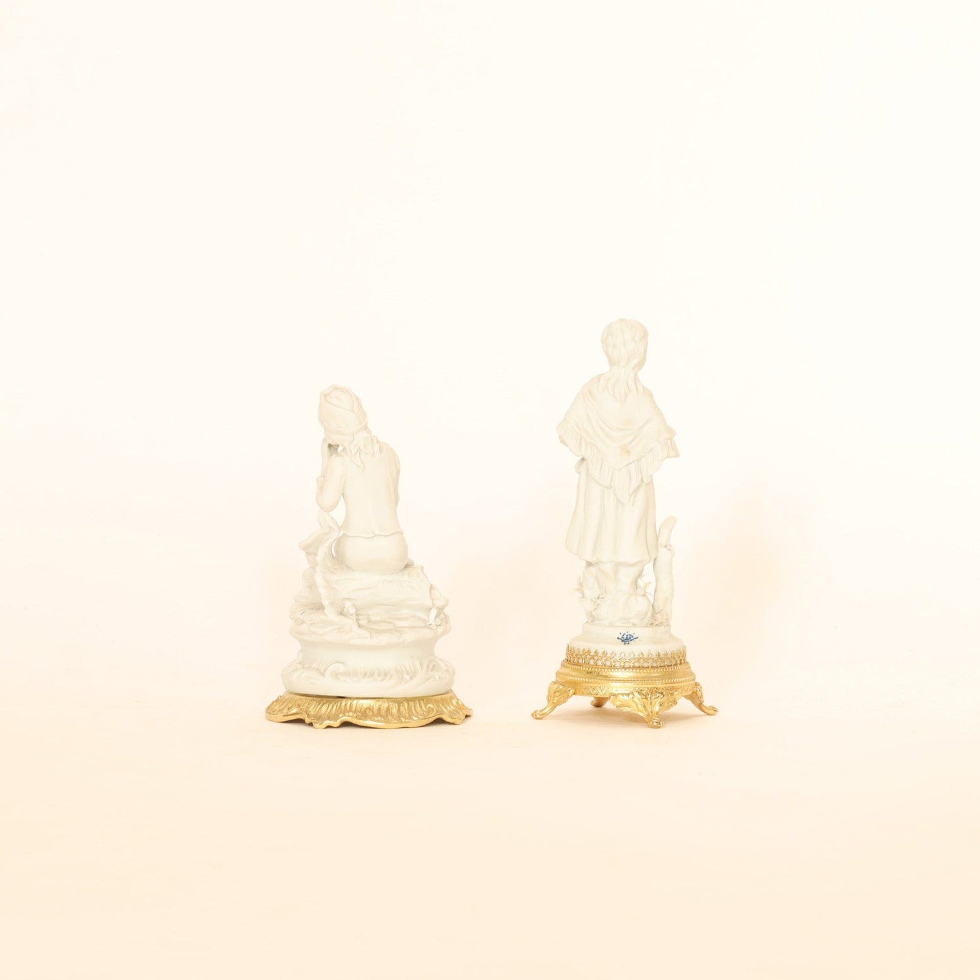 Two small figurines on a beige background