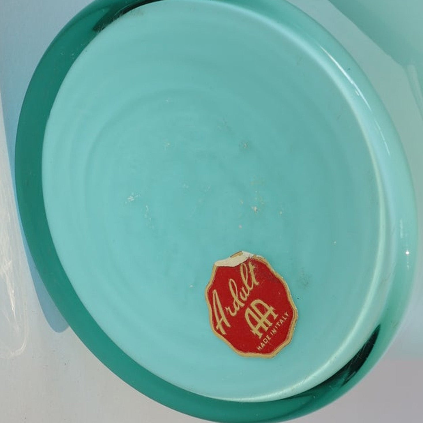A close-up of the bottom of a Vintage Pale Blue Glass Vase by Euro Trash.