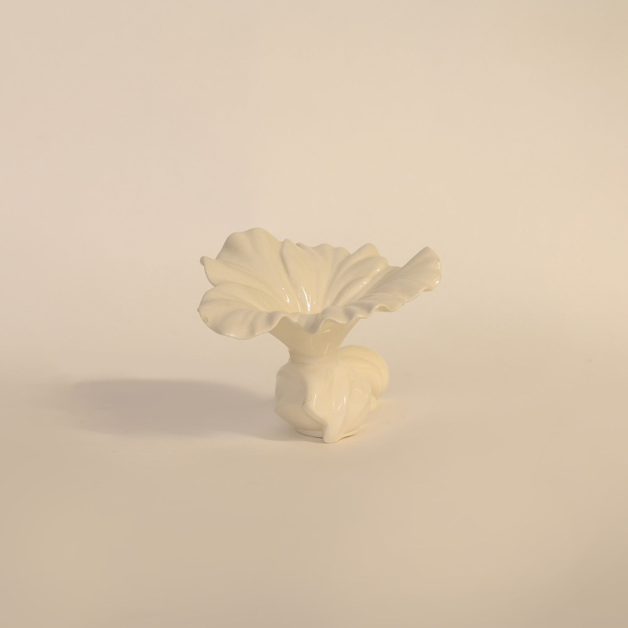 White ceramic flower sculpture on a beige background