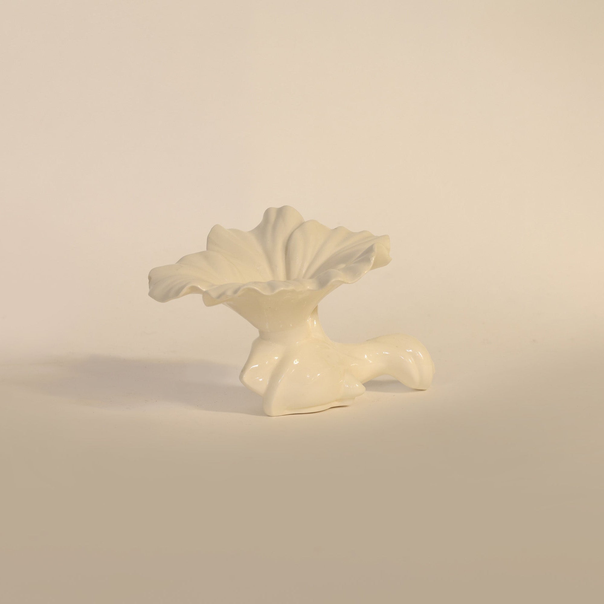 White ceramic sculpture on a beige background