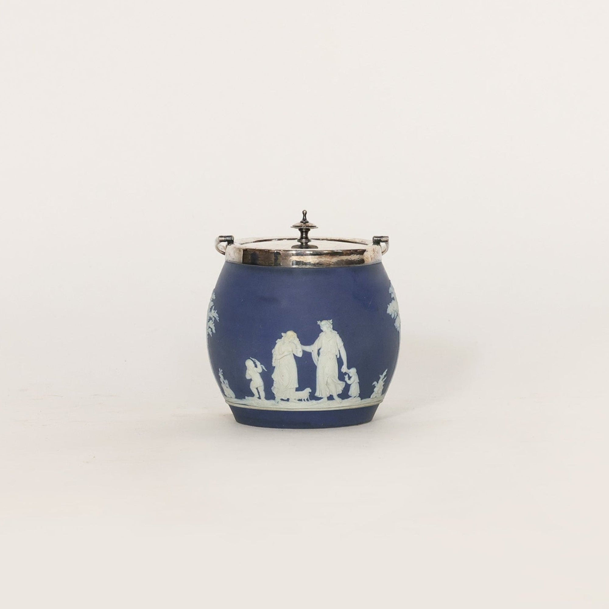 Blue ceramic jar with white decorative figures on a light gray background