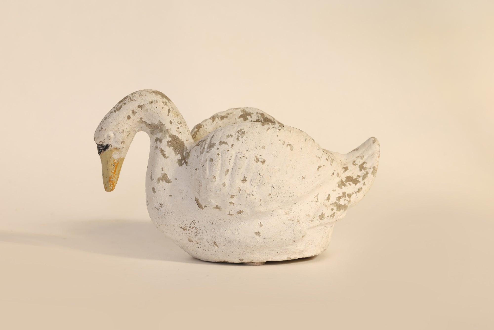 Decorative white swan figure on a beige background