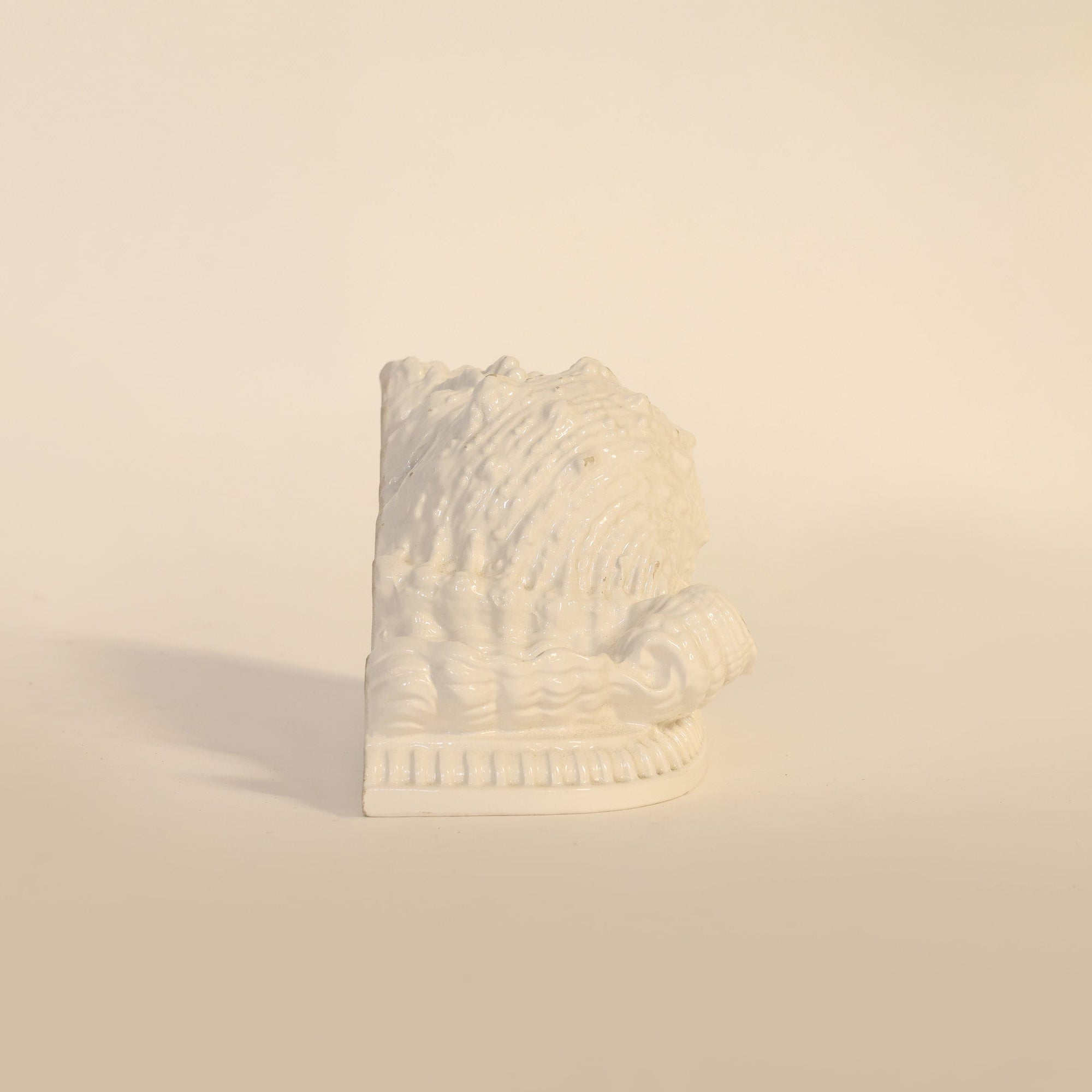 Sculptural vintage milk glass seashell on a beige background