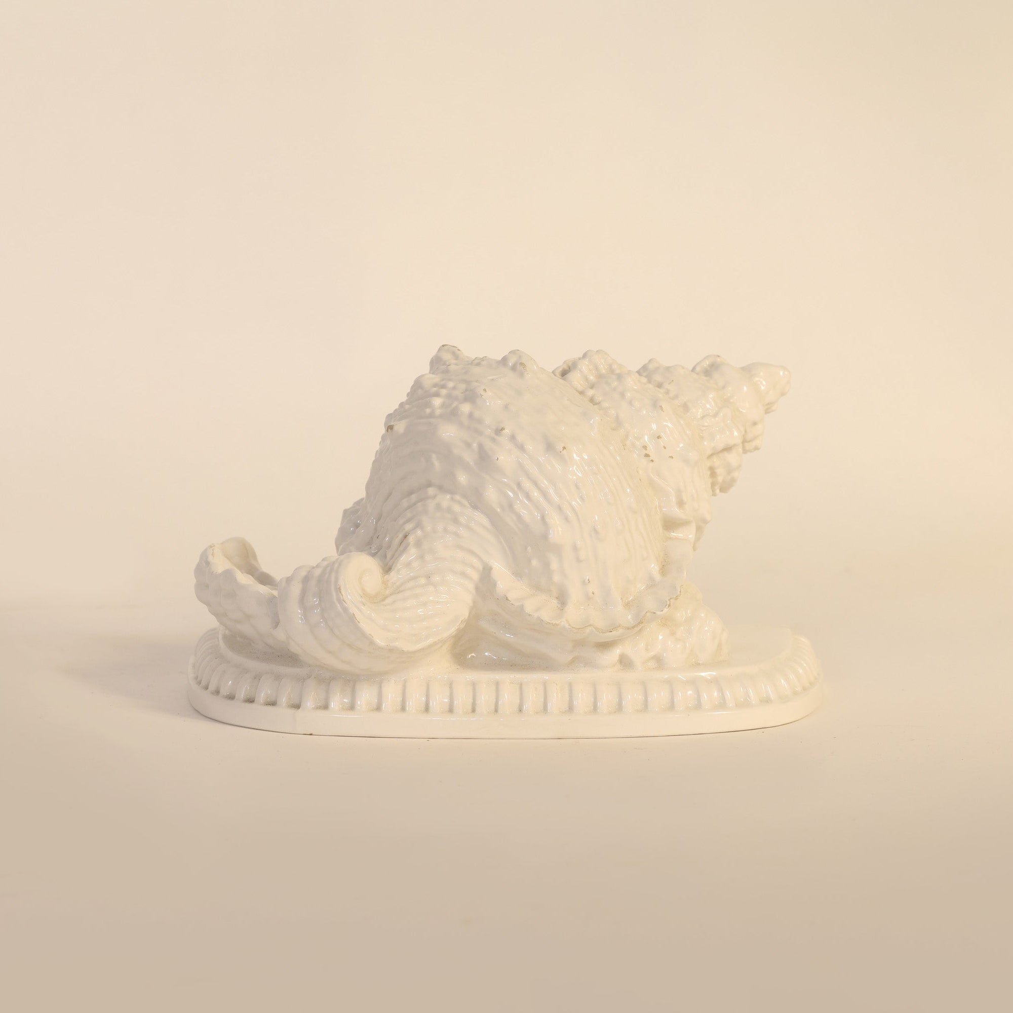 sculptural vintage milk glass seashell on a beige background