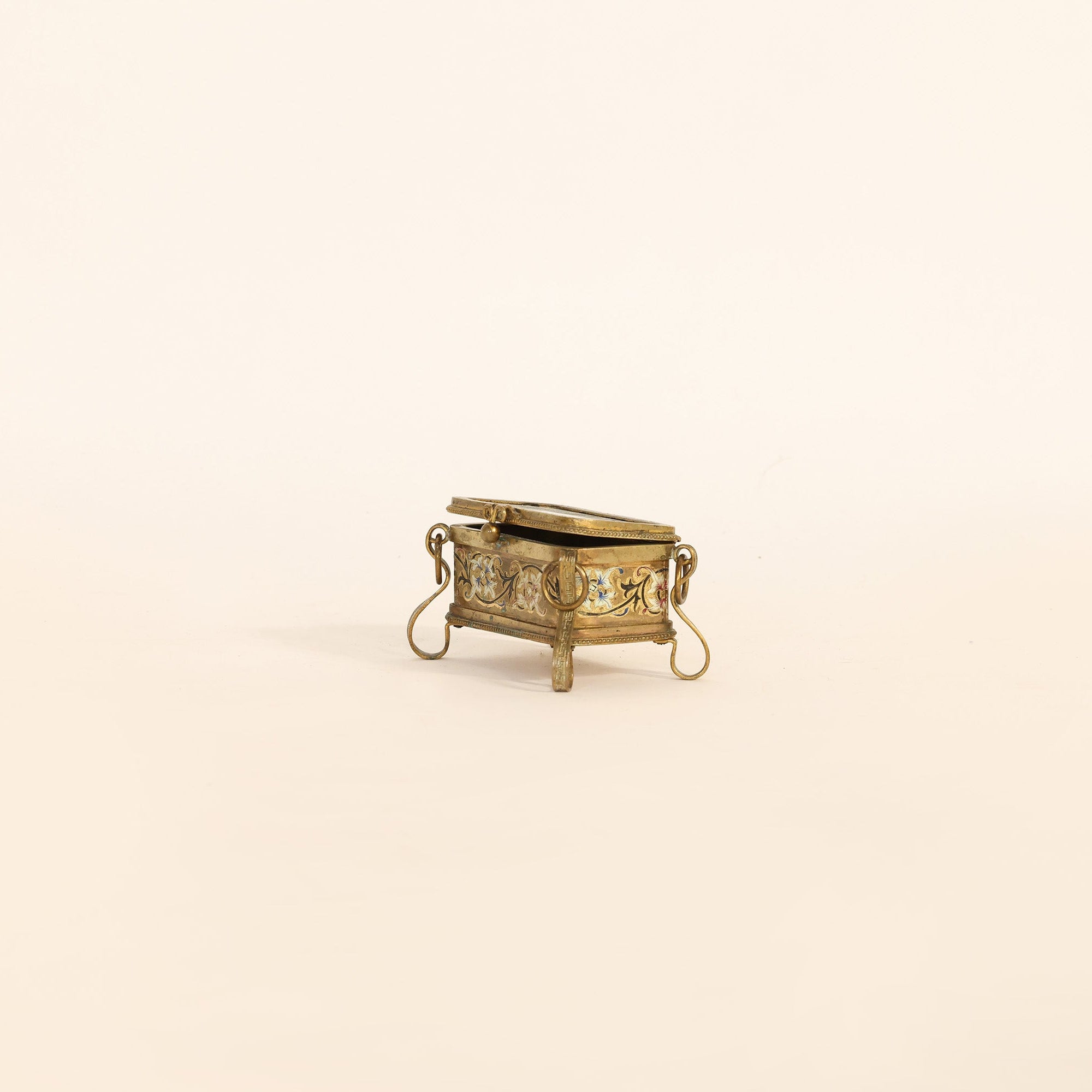Small decorative gold box on a beige background