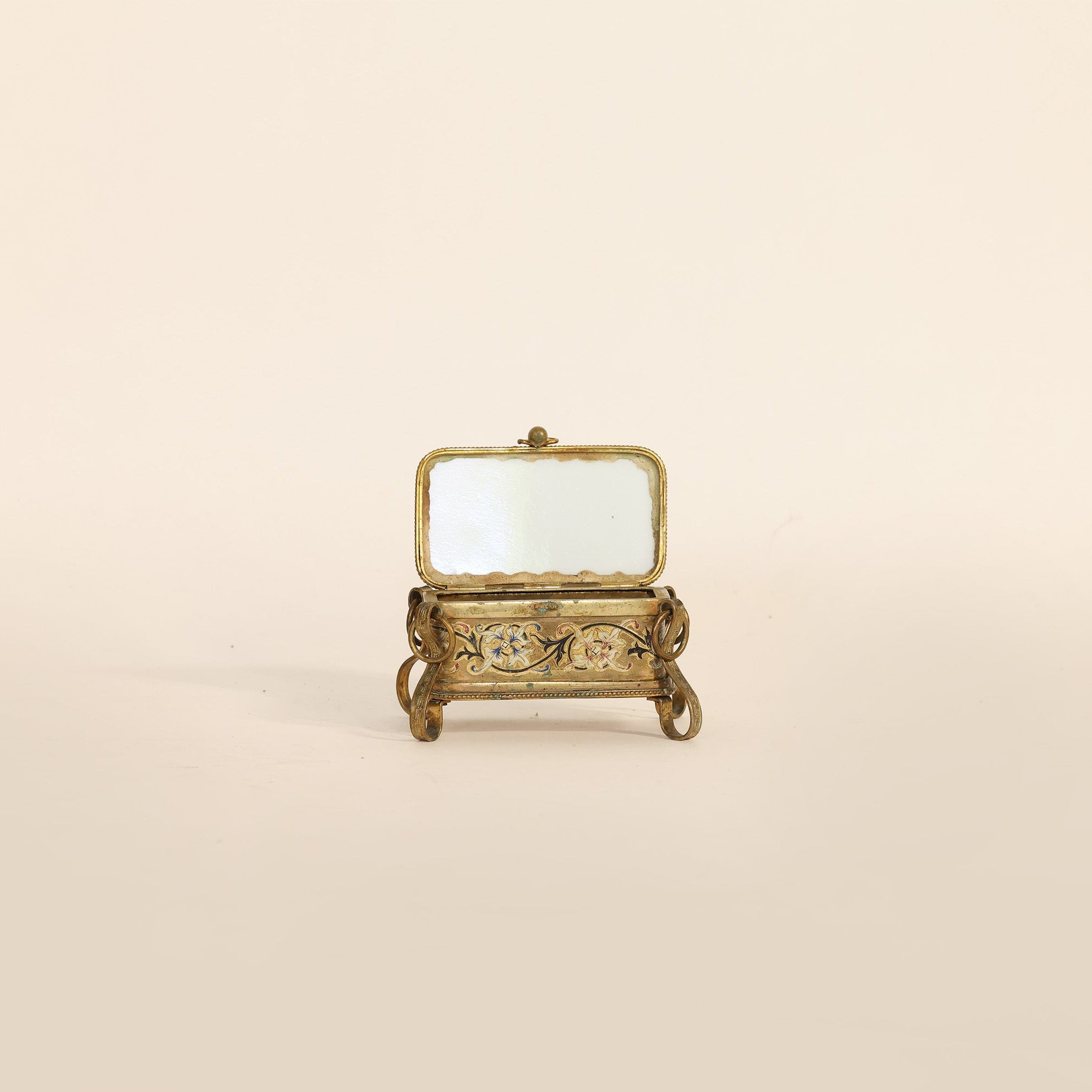 Opened gold metal box on a beige background