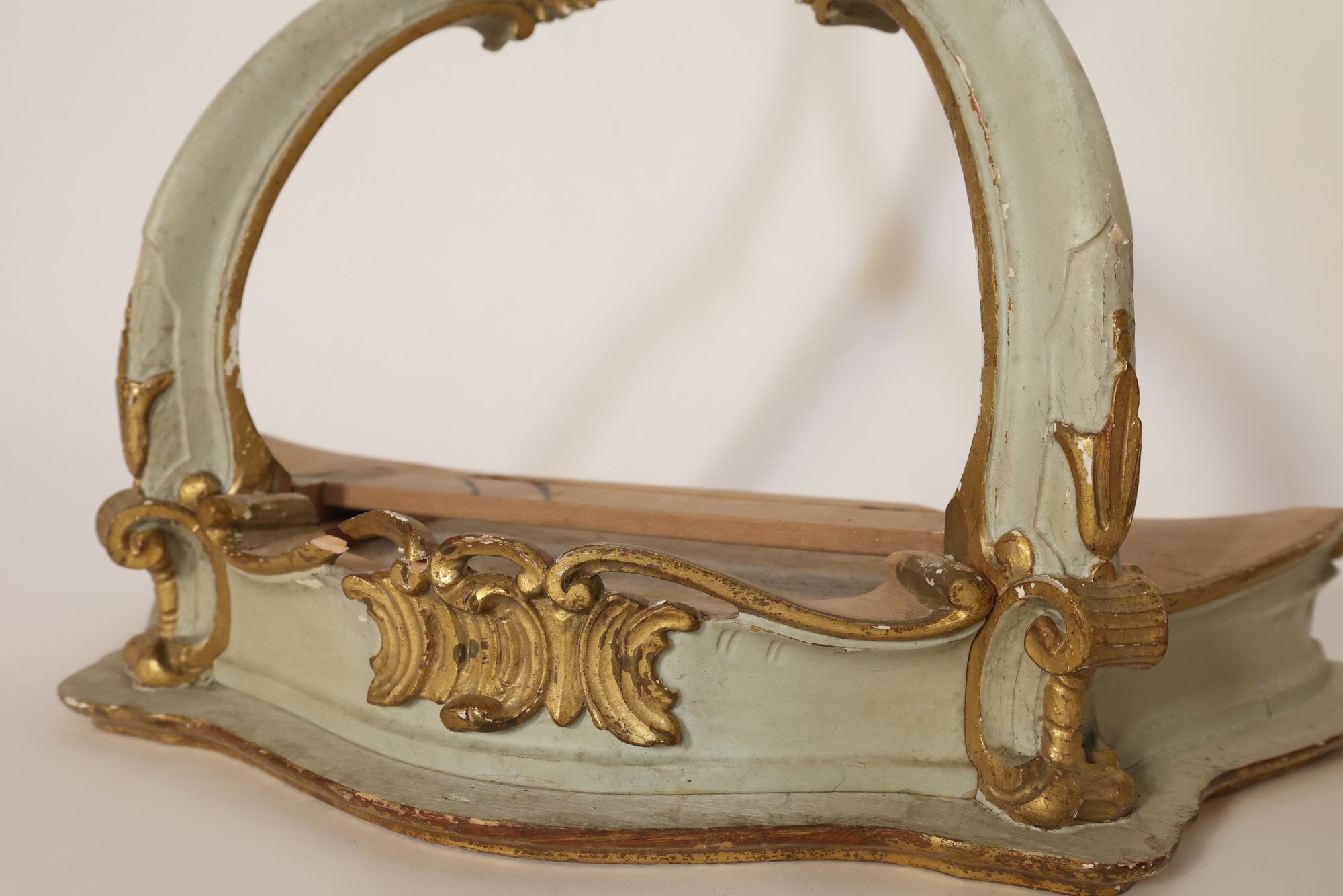 The Pair Of Vintage Giltwood Wall Corbels by Euro Trash Annie features ornate carvings, curved handles, light green and gold paint, an aged finish with visible chips, and flat wooden bases—ideal antique architectural decor.