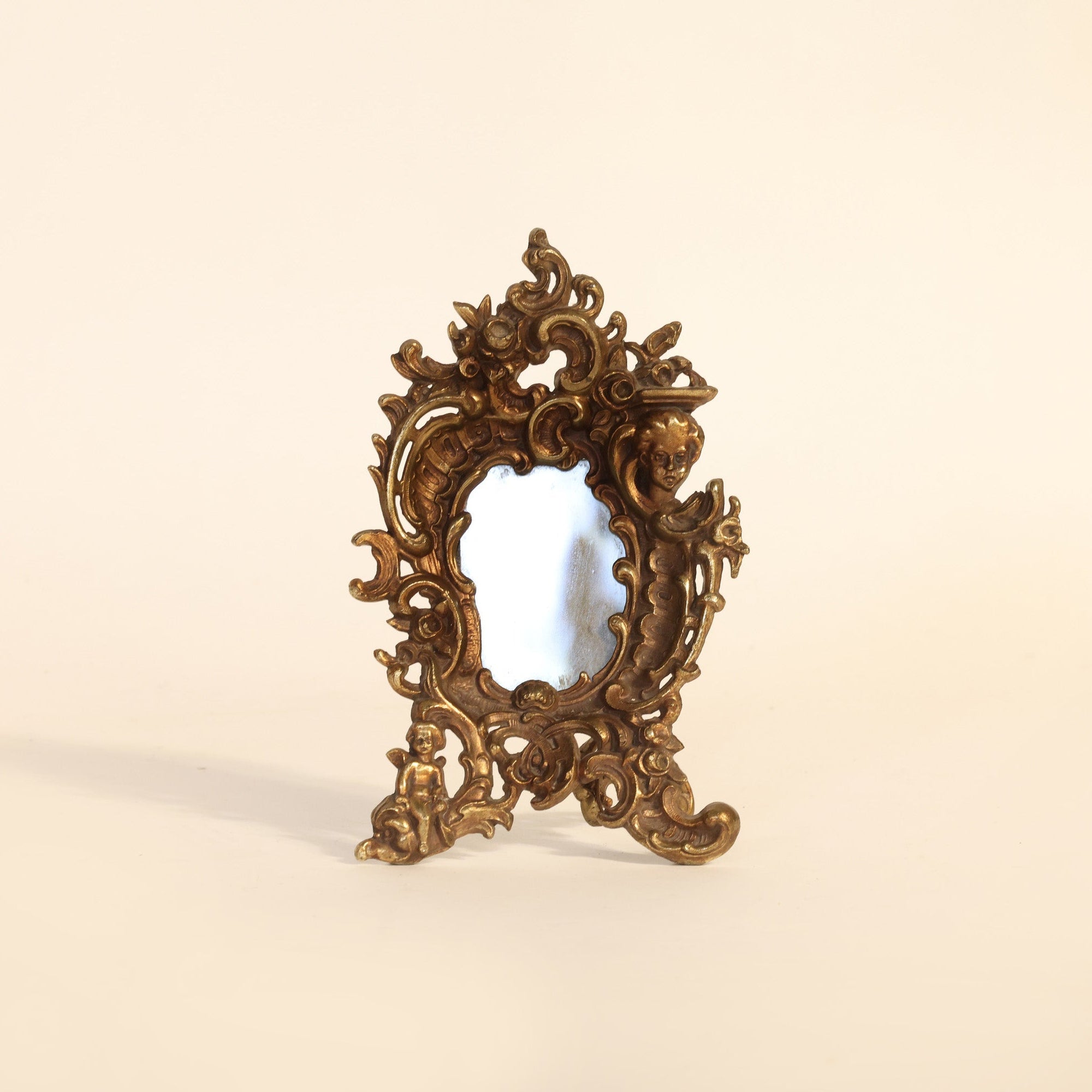 Decorative gold mirror on a beige background