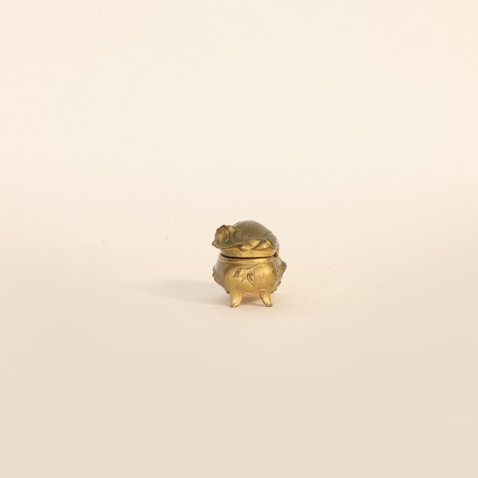 Small gold decorative box on a beige background
