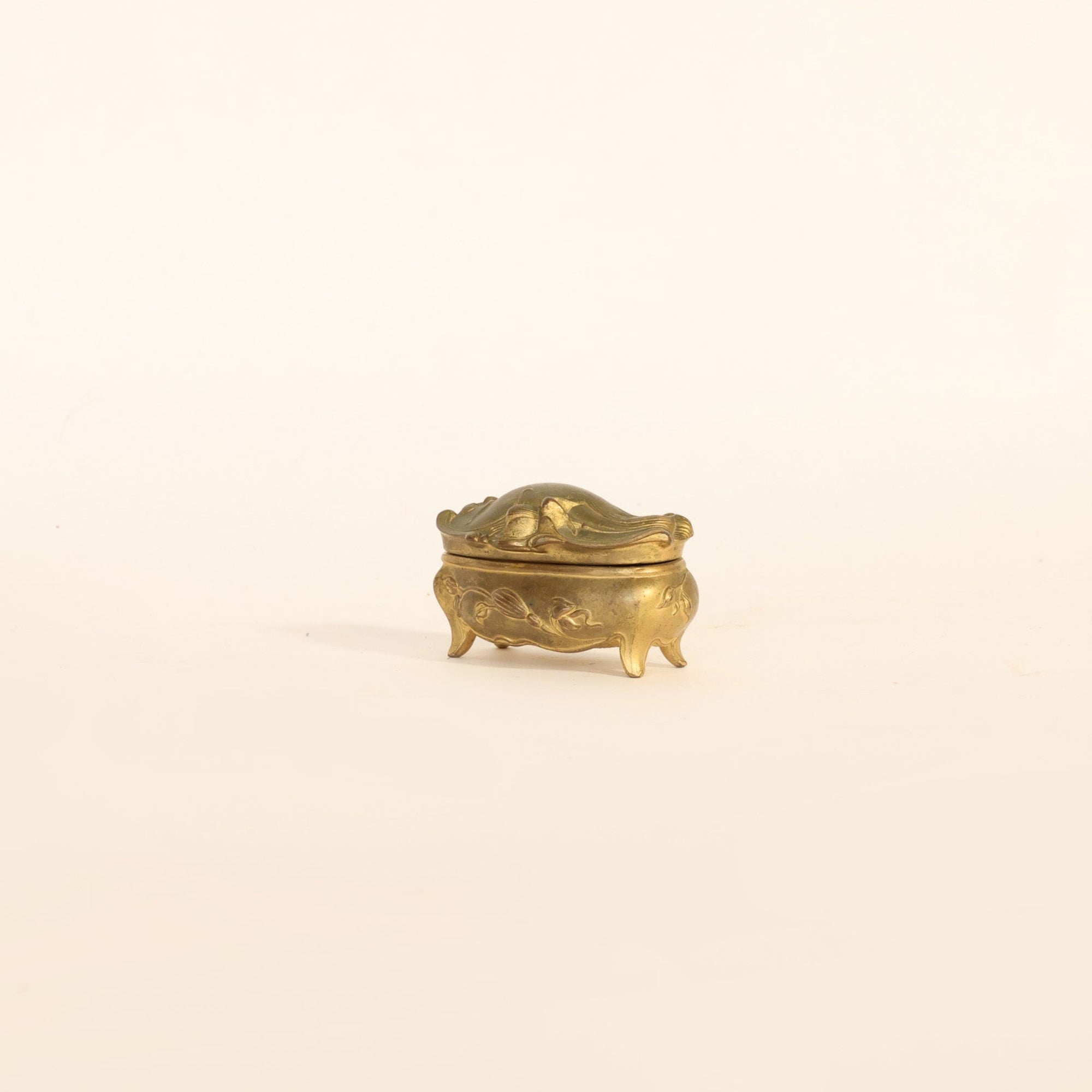 Small decorative brass box on a beige background