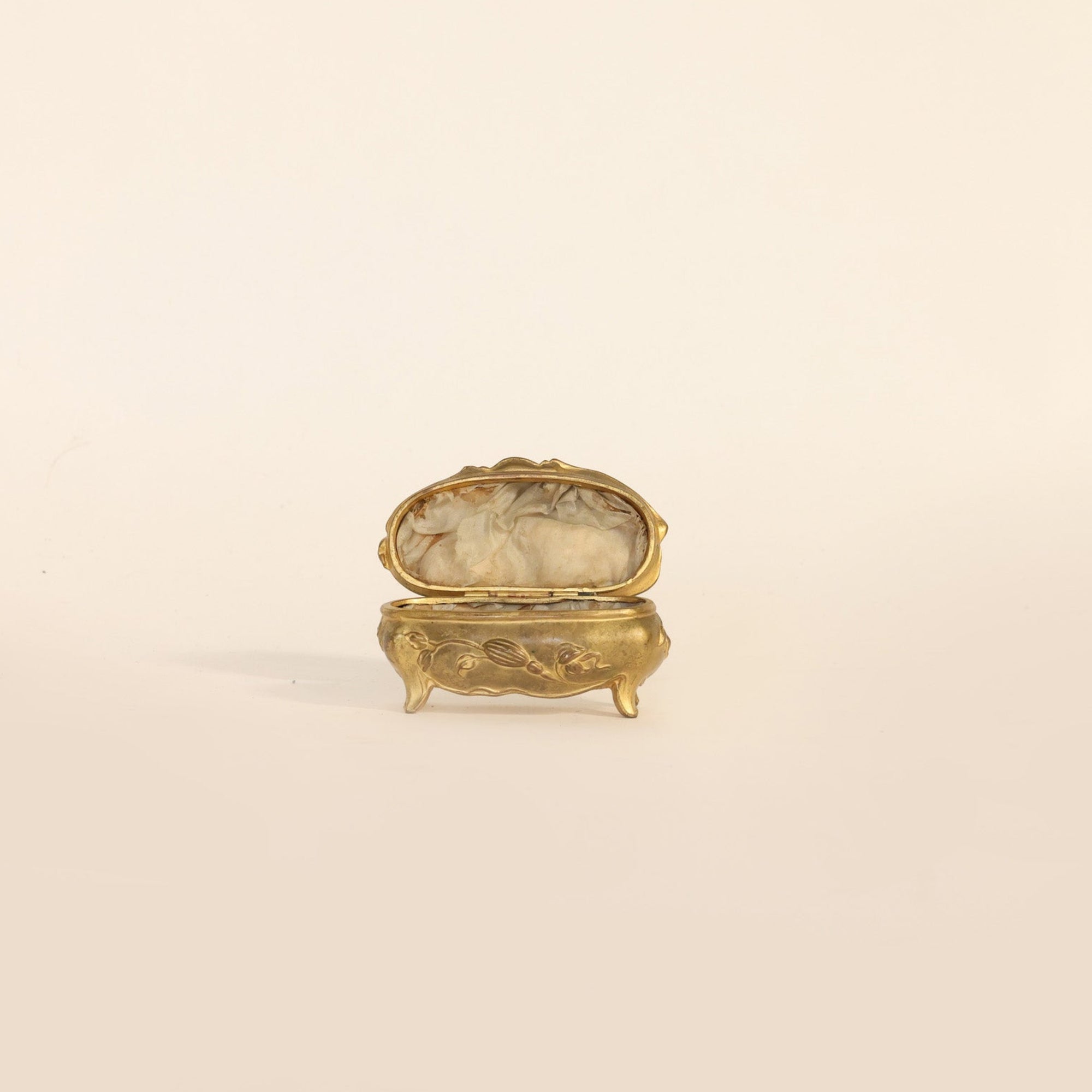 Small decorative gold box on a beige background