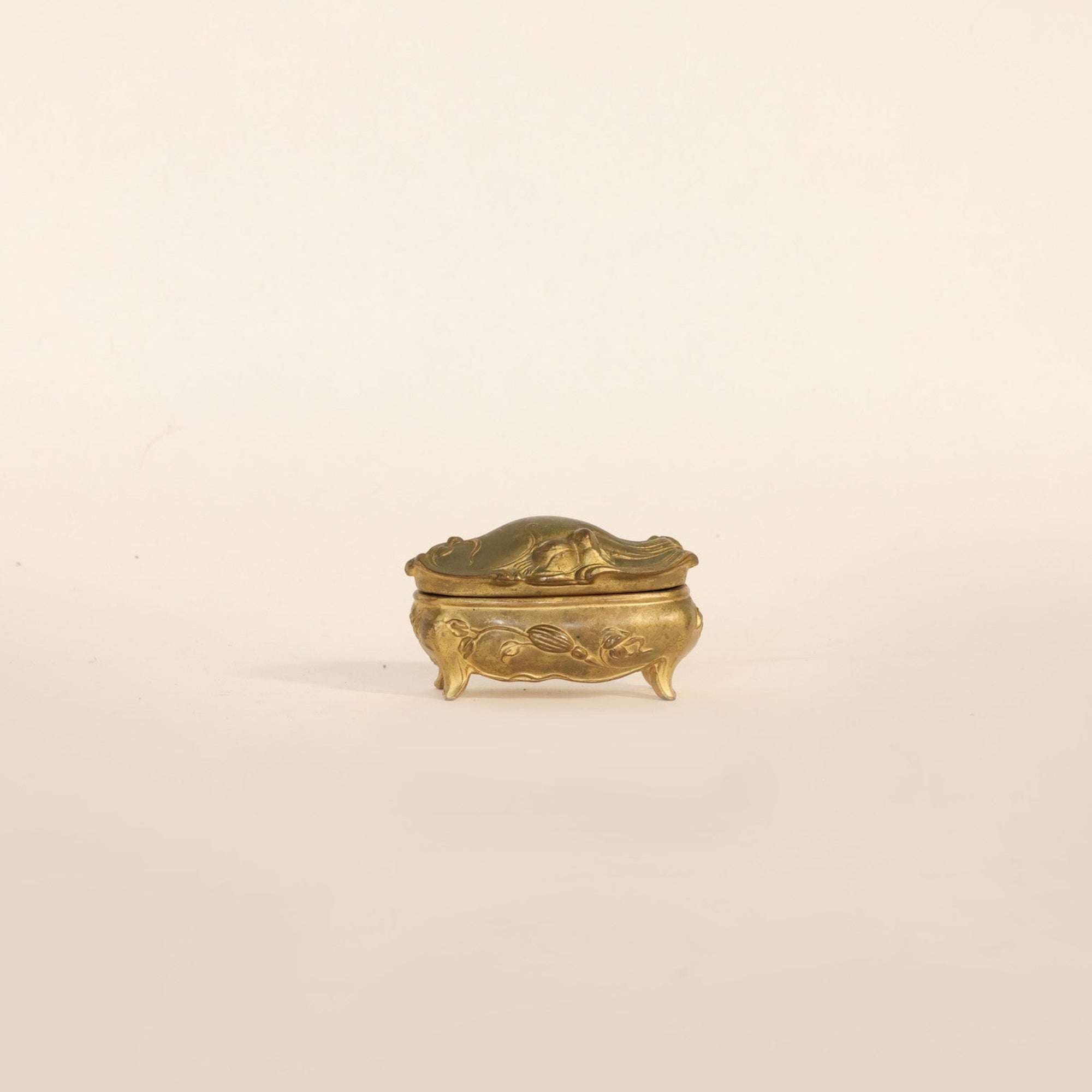 Small gold decorative box on a beige background
