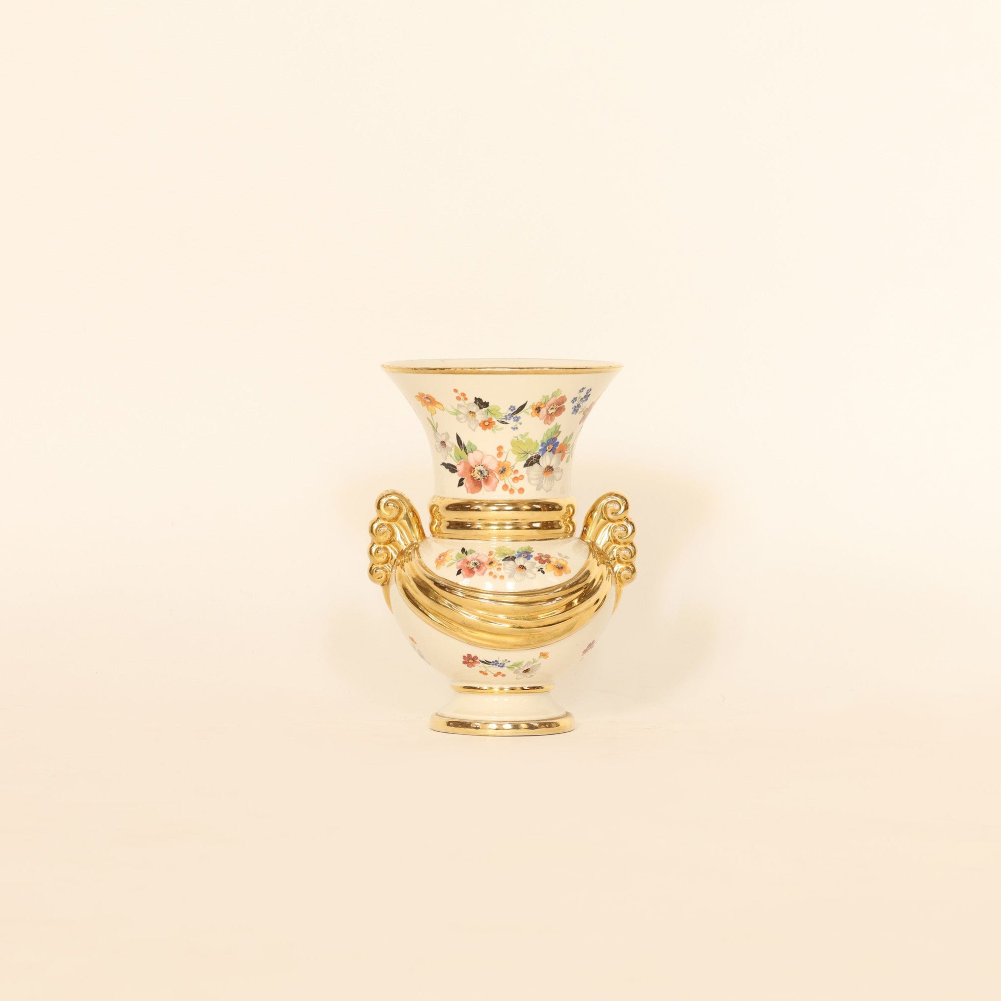 Decorative vase with floral design and gold rim on a beige background