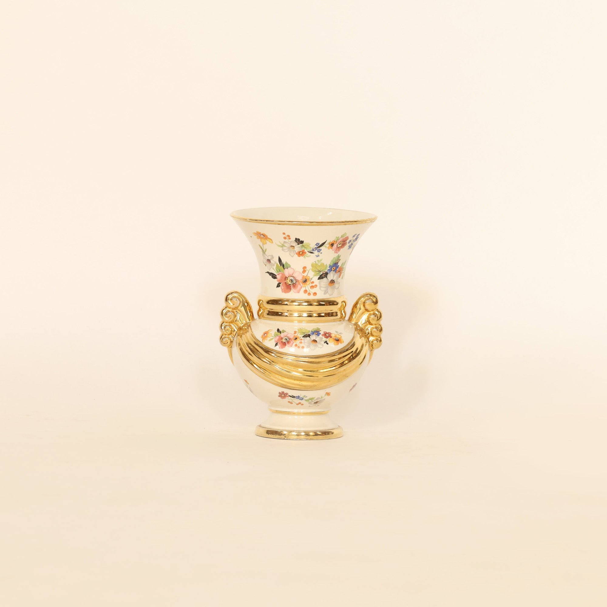 Decorative vase with floral design and gold rim on a beige background