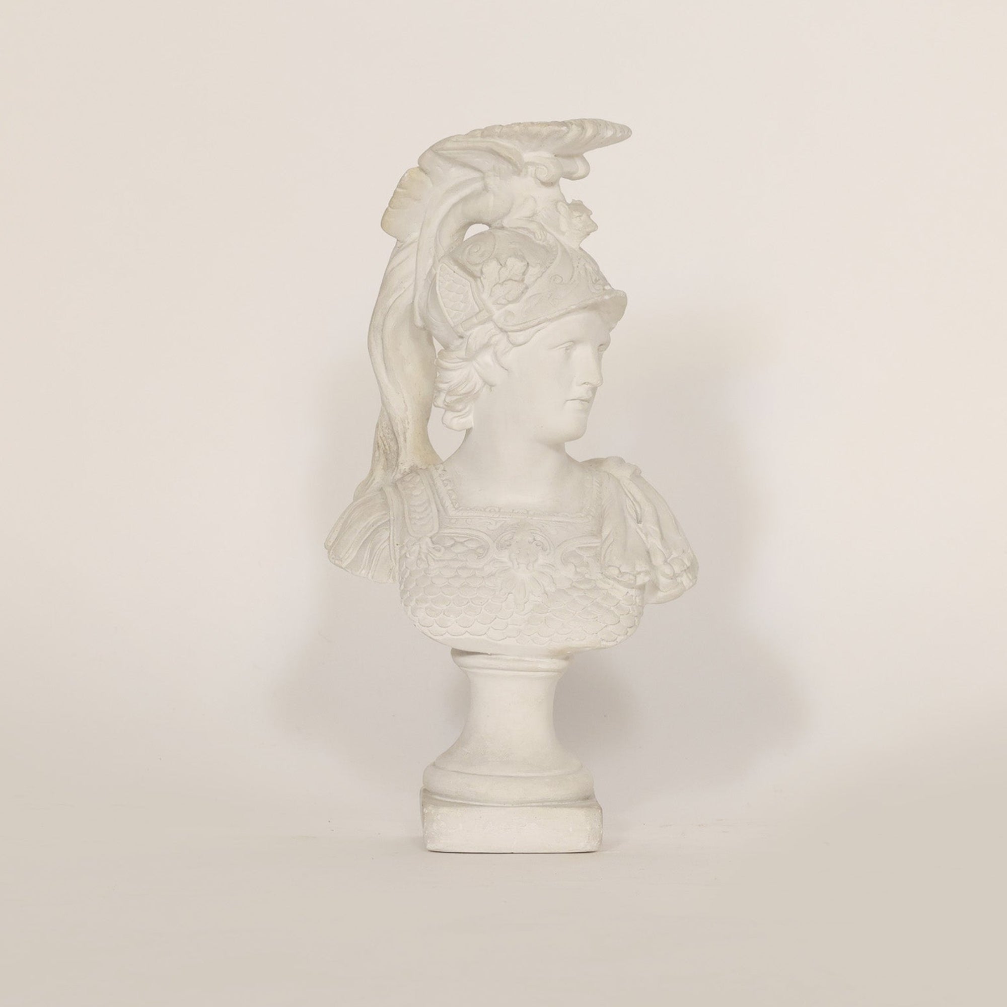 A sculptural vintage bust of Athena on beige background