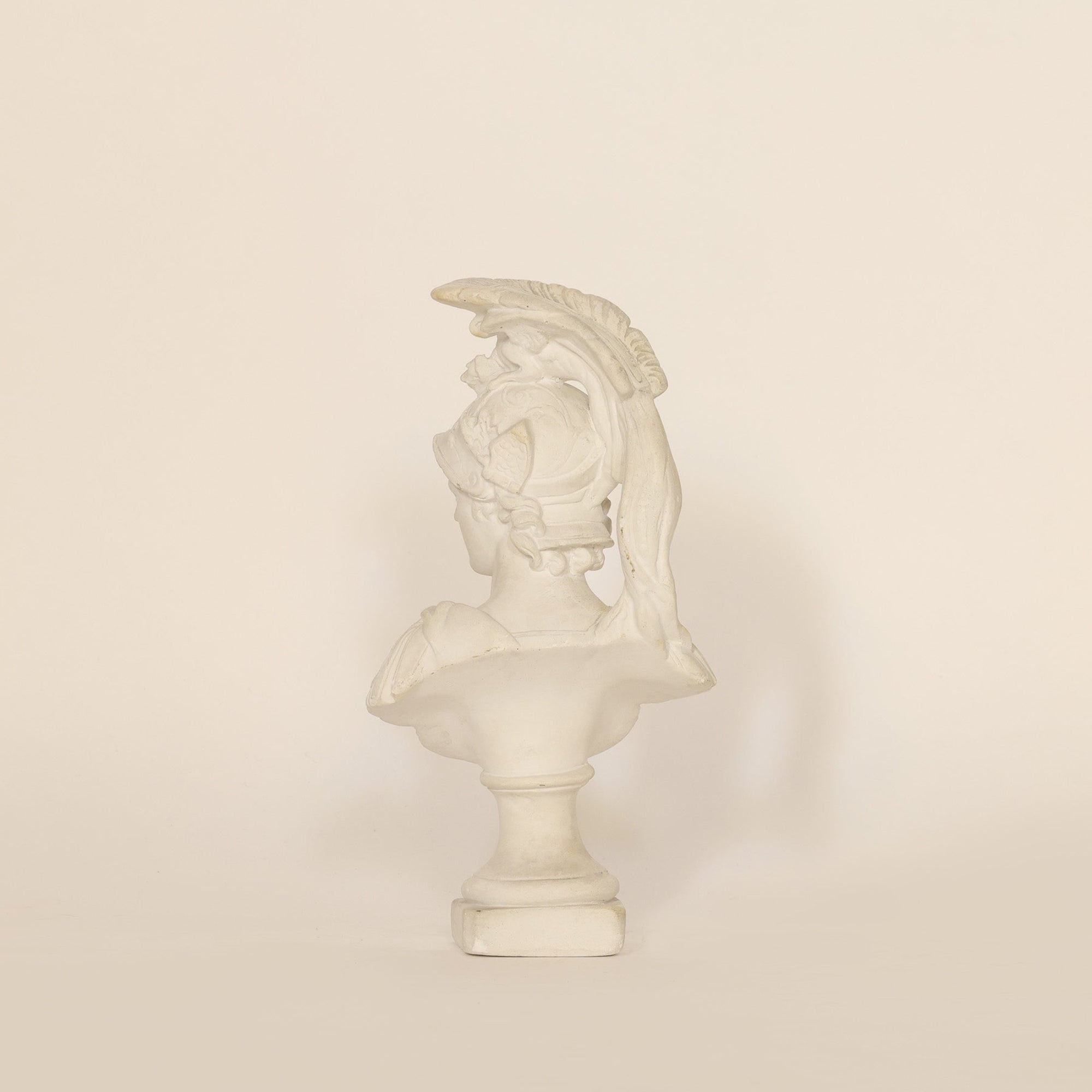 A sculptural vintage bust of Athena on beige background
