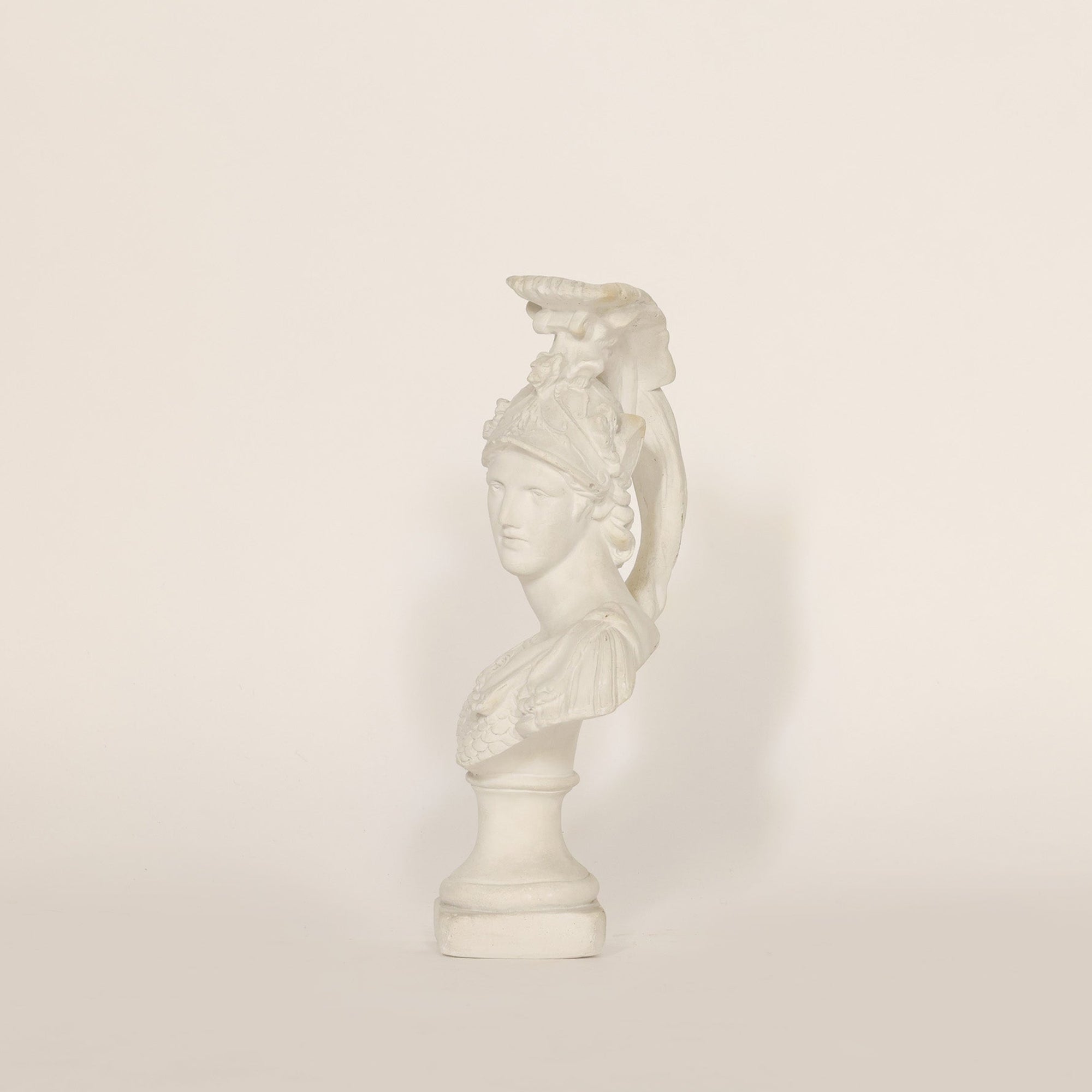 A sculptural vintage bust of Athena on beige background