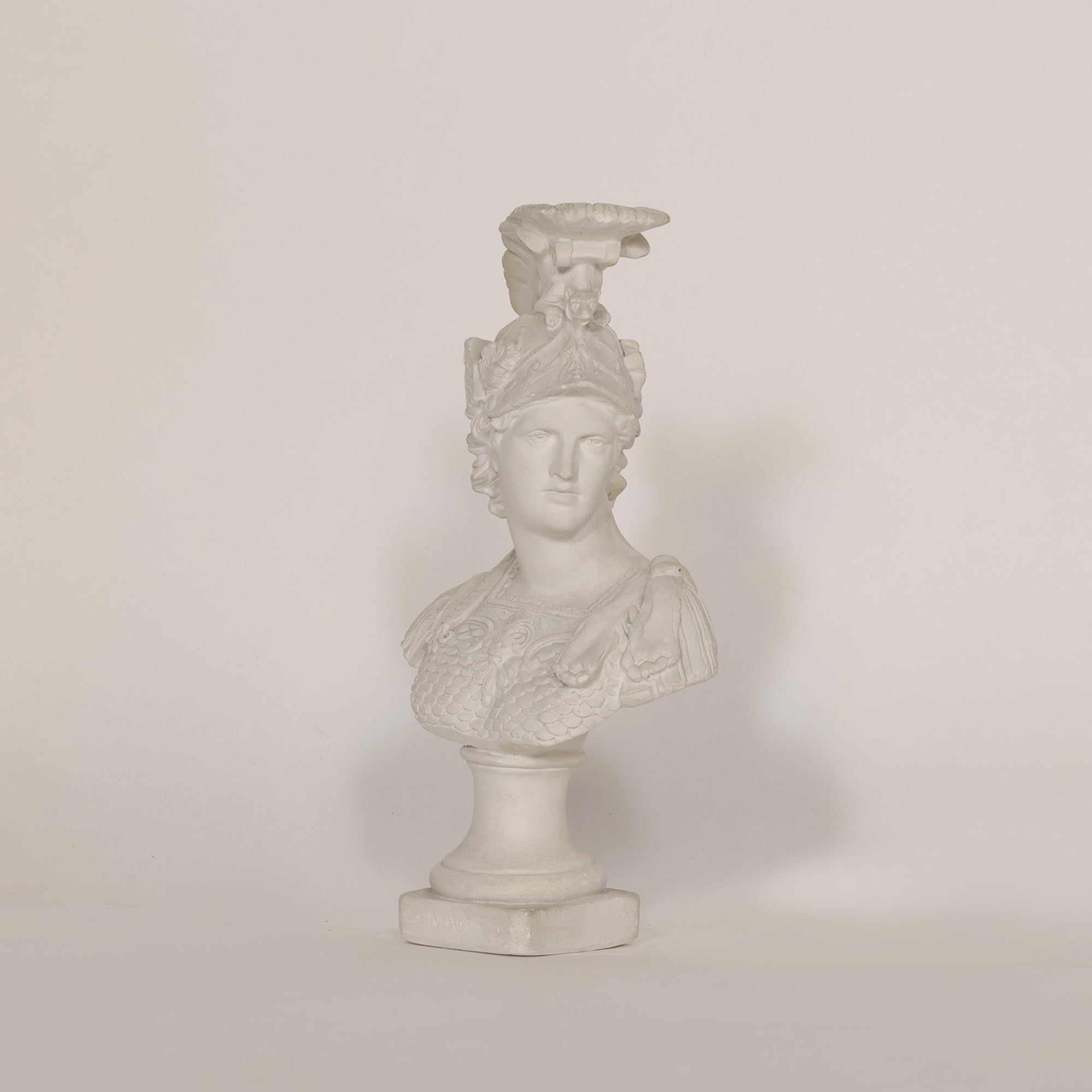 A sculptural vintage bust of Athena on beige background